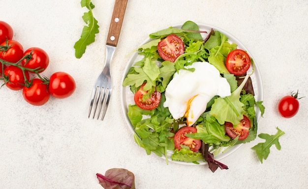 Top view salad with tomatoes and fried egg