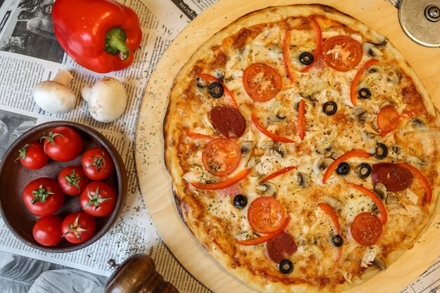 Top view salami pizza on a tray with mushrooms and tomatoes with bulgarian red pepper