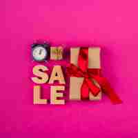 Free photo top view of sale word and presents with pink background