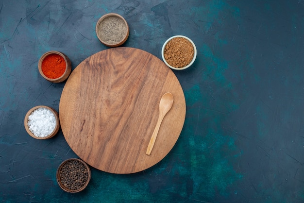 Вид сверху соль и перец с другими приправами на темно-синем столе для ингредиентов.