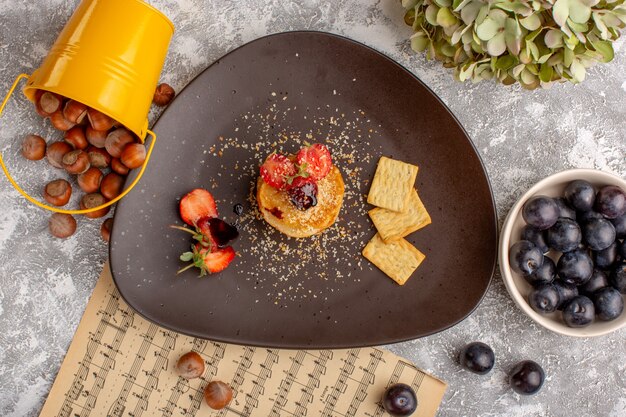 흰색 테이블에 인목 무리와 함께 접시 안에 딸기로 디자인 된 상위 뷰 소금에 절인 칩, 칩 스낵 과일 베리