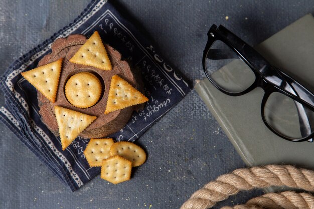 Top view salted crackers with ropes and sunglasses on the grey background crisp cracker photo snack