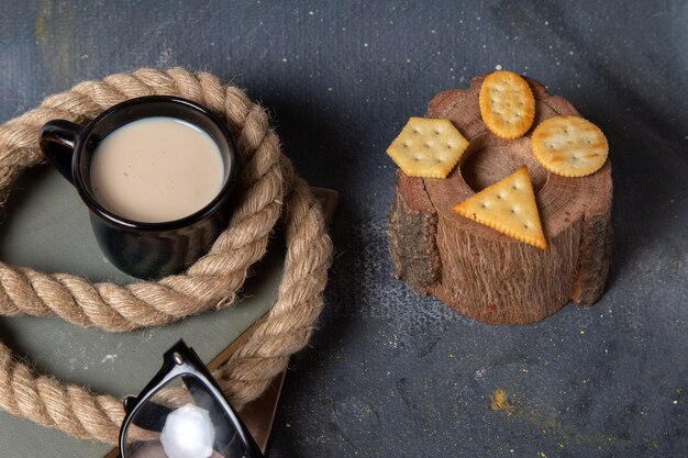 Top view salted crisps with black cup of milk on the dark desk food meal breakfast snack drink