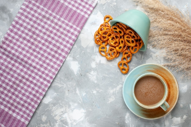 明るい背景にミルクコーヒーと塩味のポテトチップスの上面図クラックドリンクソルトスナック写真