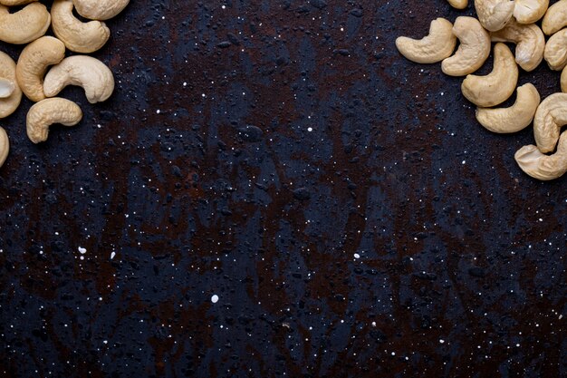 Top view of salted roasted pistachios on black background with copy space