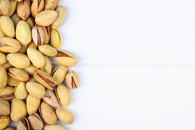 Top view of salted roasted pistachios on white background with copy space