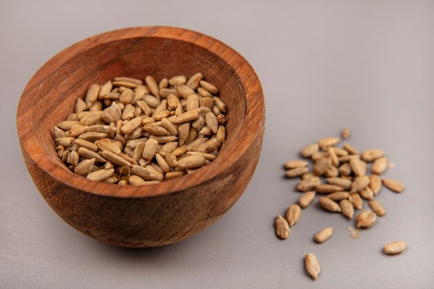 Top view of salted shelled sunflower seeds on a wooden bowl