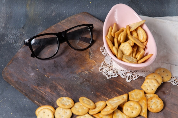 Top view salted tasty crackers with sunglasses on the wooden desk and grey background snack crisp cracker photo