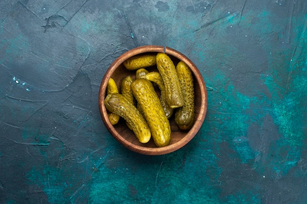 Free photo top view of salty pickles inside round brown pot on dark-blue surface