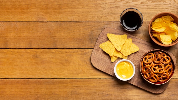 Top view salty snacks on wooden background