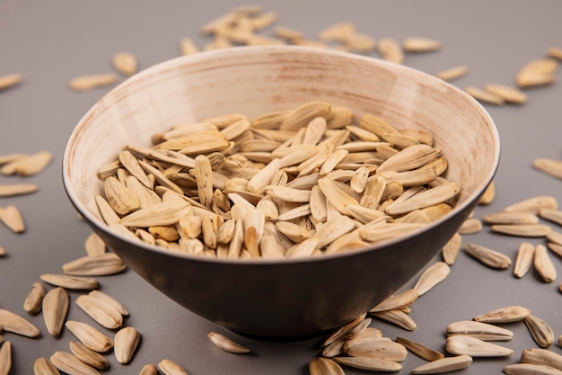 Free photo top view of salty white sunflower seeds on a bowl with sunflower seeds isolated