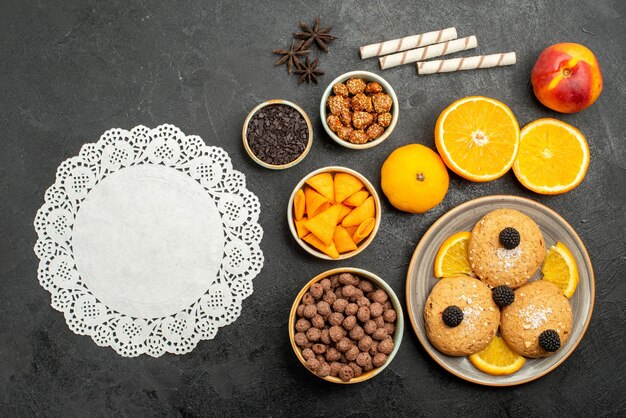 Top view sand cookies with orange slices on dark-grey surface sweet fruit biscuit cookies tea