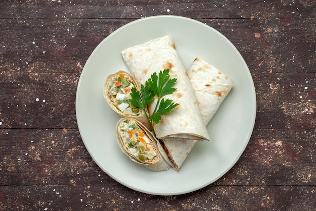 Top view sandwich rolls sliced with salad and meat inside white plate on the brown wooden desk snack food meal sandwich