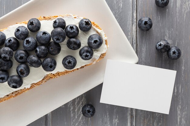 Top view sandwich with cream cheese and blueberries on plate with blank rectangle