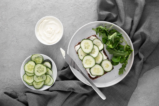 Top view sandwich with cucumbers on plate with knife