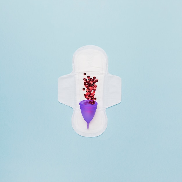 Top view sanitary towel with red sequin in menstrual cup