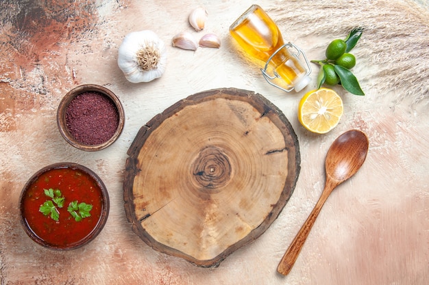 Top view sauce wooden board lemon bottle of oil sauce spices spoon