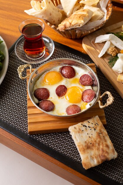Колбаса, вид сверху, яйца, чай и буханки хлеба на столе в ресторане, еда, завтрак