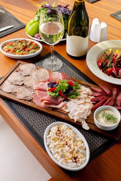 A top view sausages on desk with white wine and vegetables on the table food meal restaurant meat