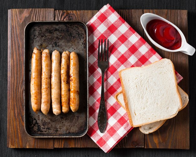 Top view sausages on tray with bread