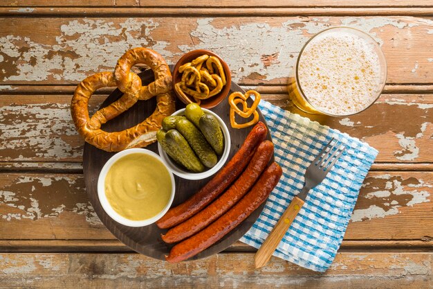 Top view of sausages with pickles and beer