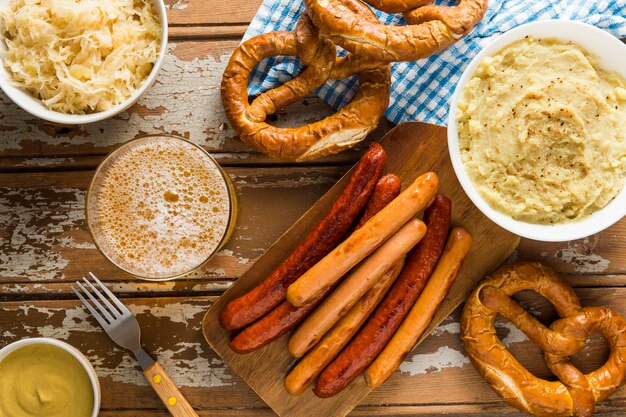 Top view of sausages with pretzels and beer