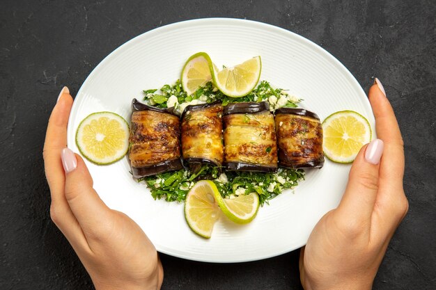 Top view savory eggplant rolls cooked dish with lemon slices on dark surface dinner oil cooking meal dish