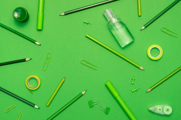 Top view school items on green background