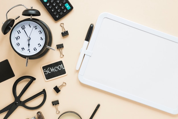 Top view of school supplies and alarm clock