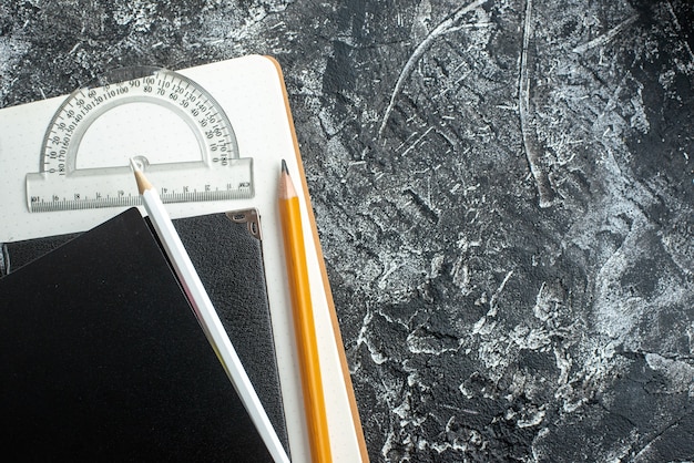 Top view of school supplies on dark surface