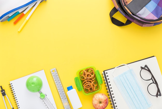 Top view of school supplies with notebook and glasses
