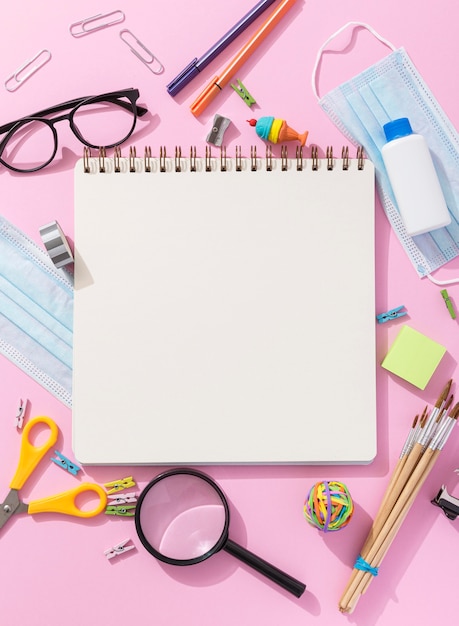 Top view of school supplies with notebook and magnifying glass