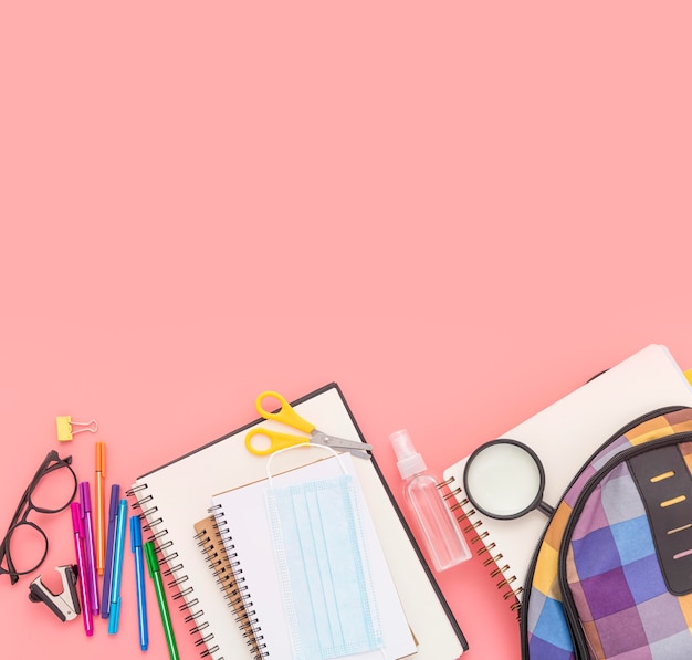 Top view of school supplies with notebooks and book bag