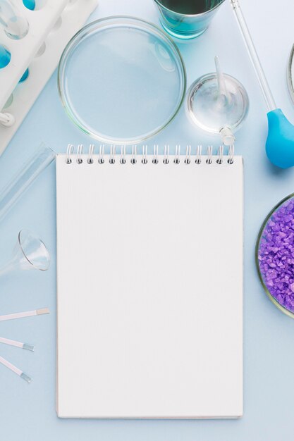 Top view science elements in lab with empty notepad