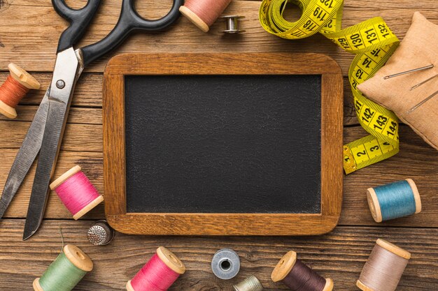 Top view of scissors with measuring tape and chalkboard