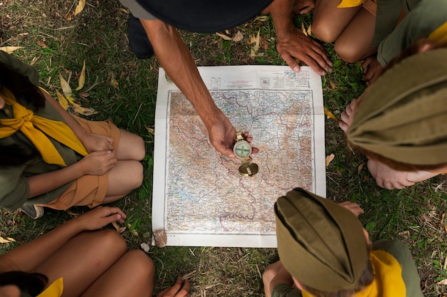 Free photo top view scouts playing with map