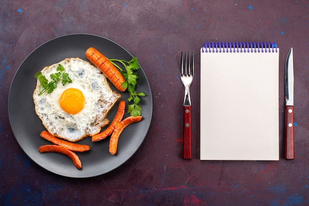 Free photo top view of scrambled eggs with greens and sausages inside plate on the dark-purple surface