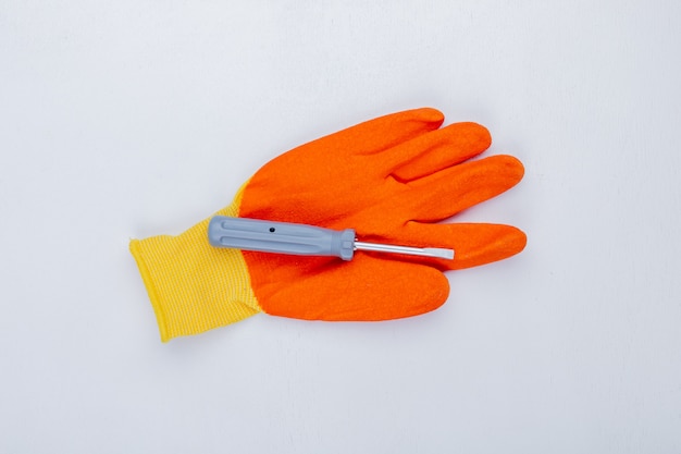 Top view of screwdriver on glove on white background