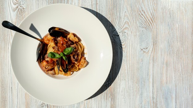 Top view of sea food pasta on wooden table