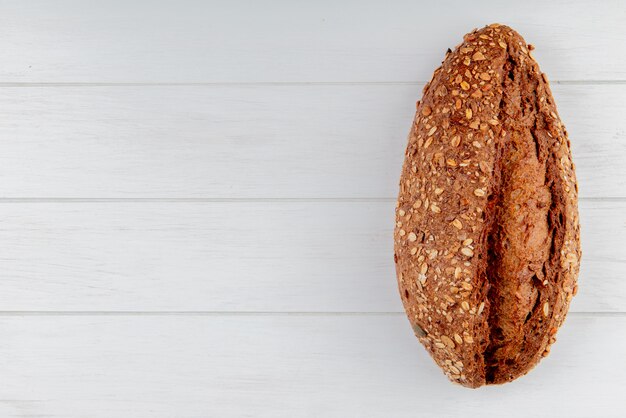 Top view of seeded vietnamese baguette on right side and wooden background with copy space