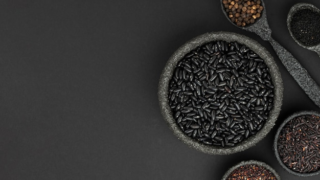 Top view of seeds and condiments in bowls with copy space