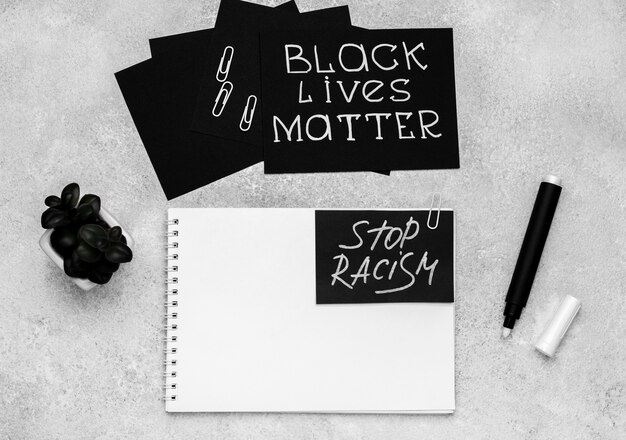 Top view of selection of cards with black lives matter and notebook