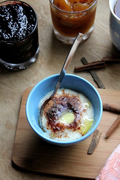 Free photo top view semolina porridge with cinnamonnd jam on the table