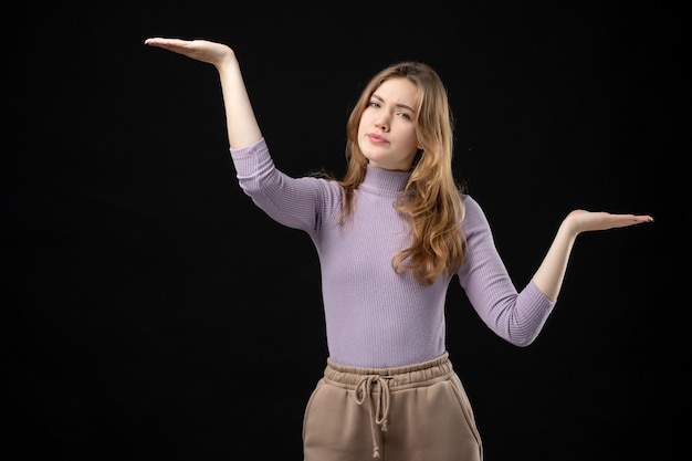 Free photo top view of serious blonde girl making exact something on dark