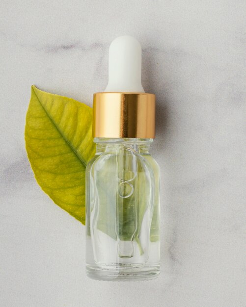 Top view serum bottle and leaf