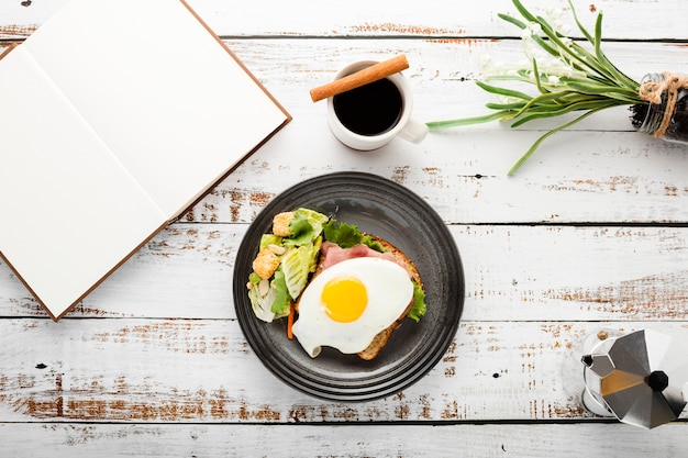 Top view set of breakfast sandwich next to notebook