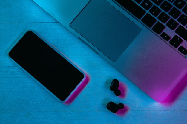 Top view of set of gadgets in purple neon light and blue