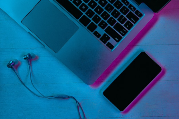 Top view of set of gadgets in purple neon light and blue