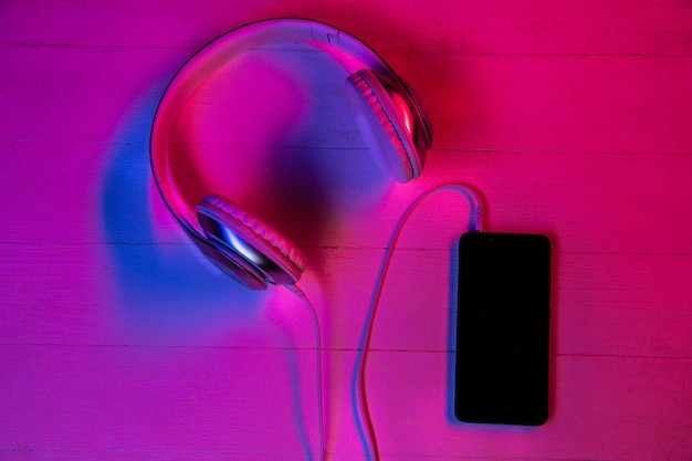 Free photo top view of set of gadgets in purple neon light and pink