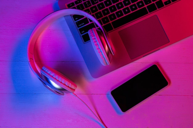 Top view of set of gadgets in purple neon light and pink